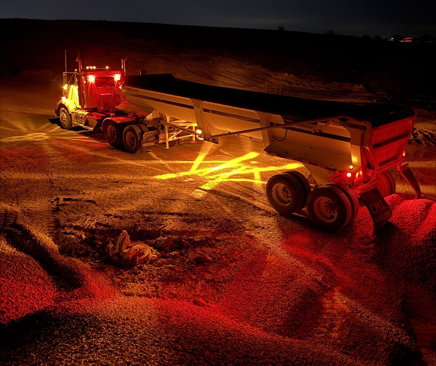End dump trailer lit up at a quarry at night